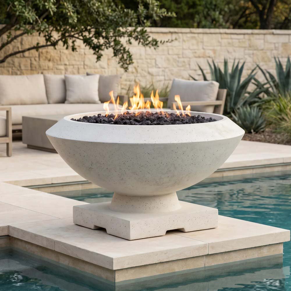 Concrete gas fire bowl with lit flames in round basin and dark fire glass; pedestal base