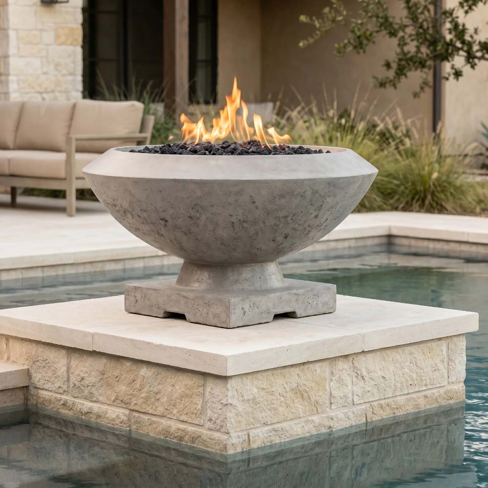 Concrete gas fire bowl in gray concrete finish with flames and black lava rock