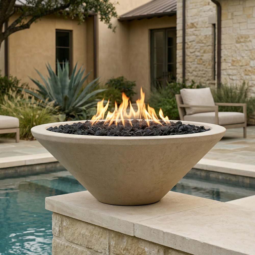 Pedestal concrete gas fire pit with flame and black lava rocks beside outdoor seating