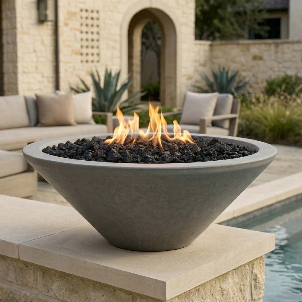 Pedestal concrete gas fire pit with flame and black lava rocks on stone pedestal