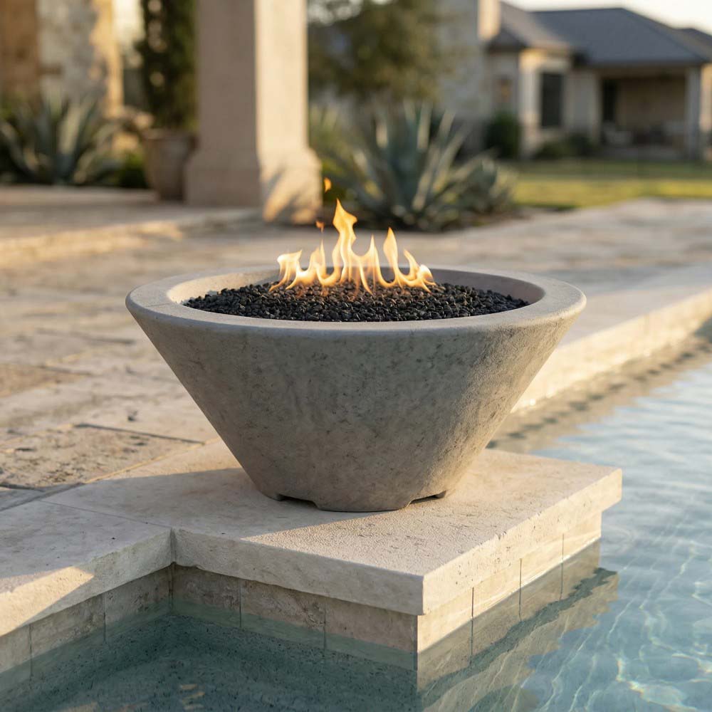 Gray concrete fire bowl with black lava rock and open flame on pedestal