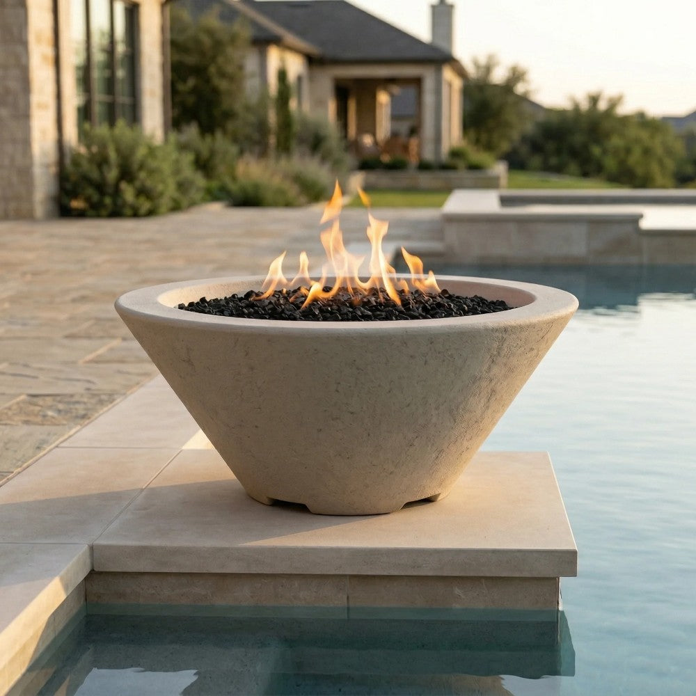 Light gray concrete gas fire bowl with open flame and black lava rock on stone ledge