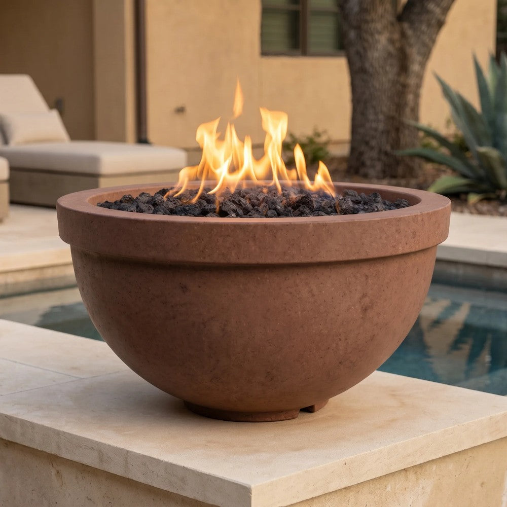 Round cafe-color concrete gas fire bowl with flame and black lava rock inside.