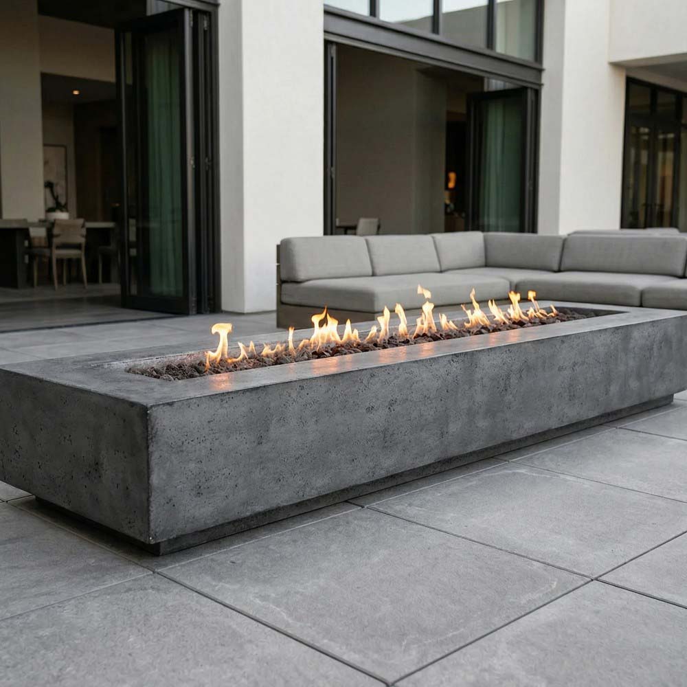 Rectangular concrete gas fire pit with visible flames and lava rock bed