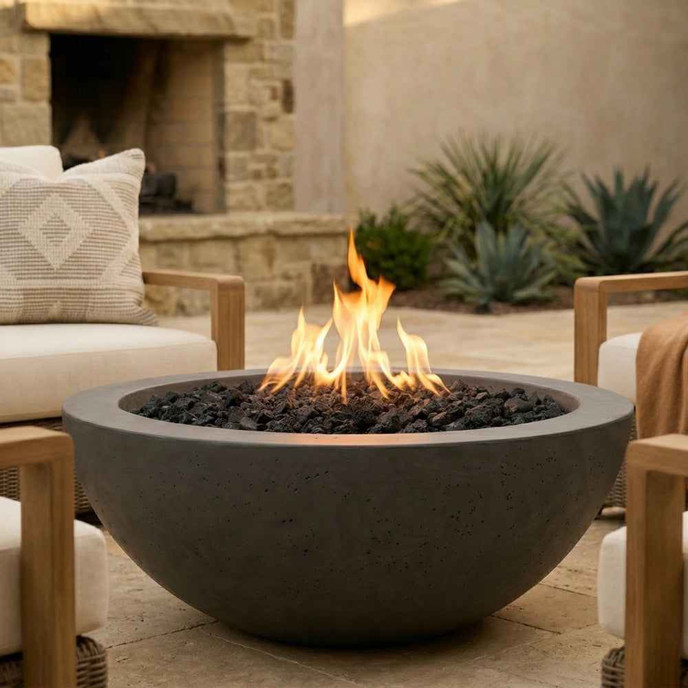 Modern concrete gas fire bowl with glowing flames and black lava rocks