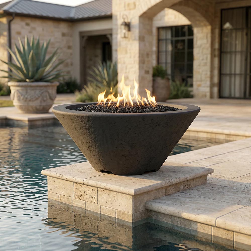 Tan concrete gas fire bowl on stacked stone base with burning flames and black lava rock