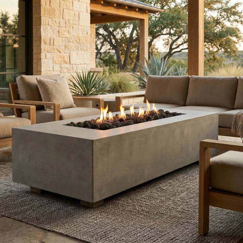 Rectangular concrete gas fire pit with active flames in a dark burner bed