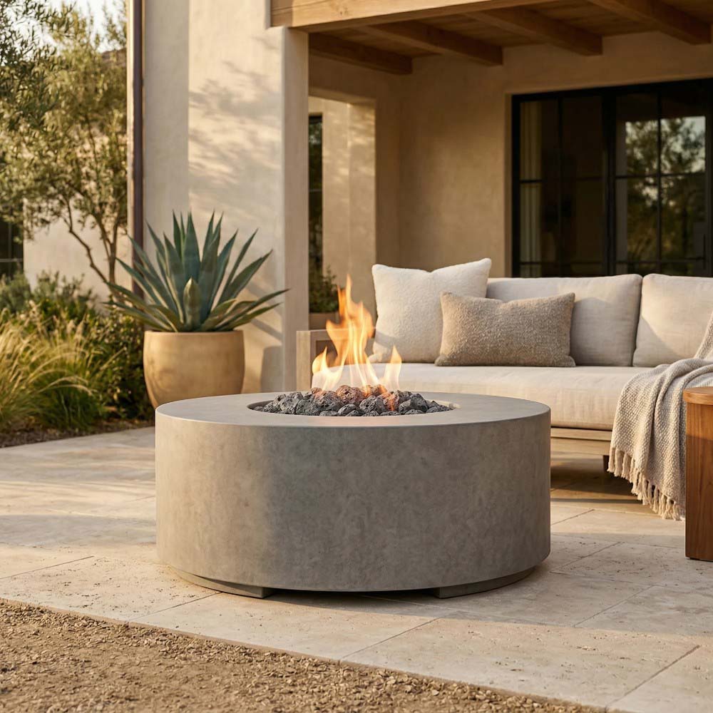 Round concrete gas fire pit on patio, light grey bowl with flame