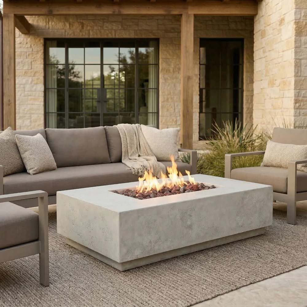 Light concrete gas fire pit with open flame in a rectangular firebox.