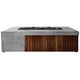 Concrete gas fire pit with dark wood slats and black lava rocks on top