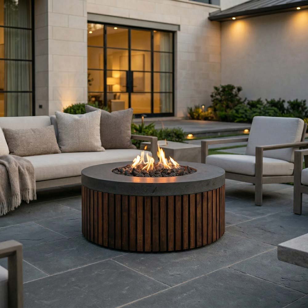 Round gas fire pit with dark top, burning flames, and vertical wood-slat surround