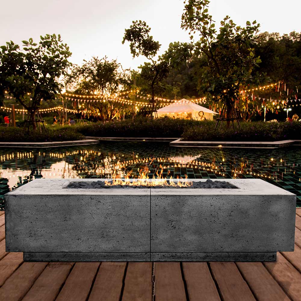 Concrete gas fire pit with flames in rectangular burner, square firebox, gray finish.