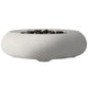 Concrete gas fire bowl with smooth oval rim and dark lava rocks, pale gray finish.