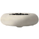 Concrete gas fire bowl with smooth oval rim and dark lava rocks, light beige finish.