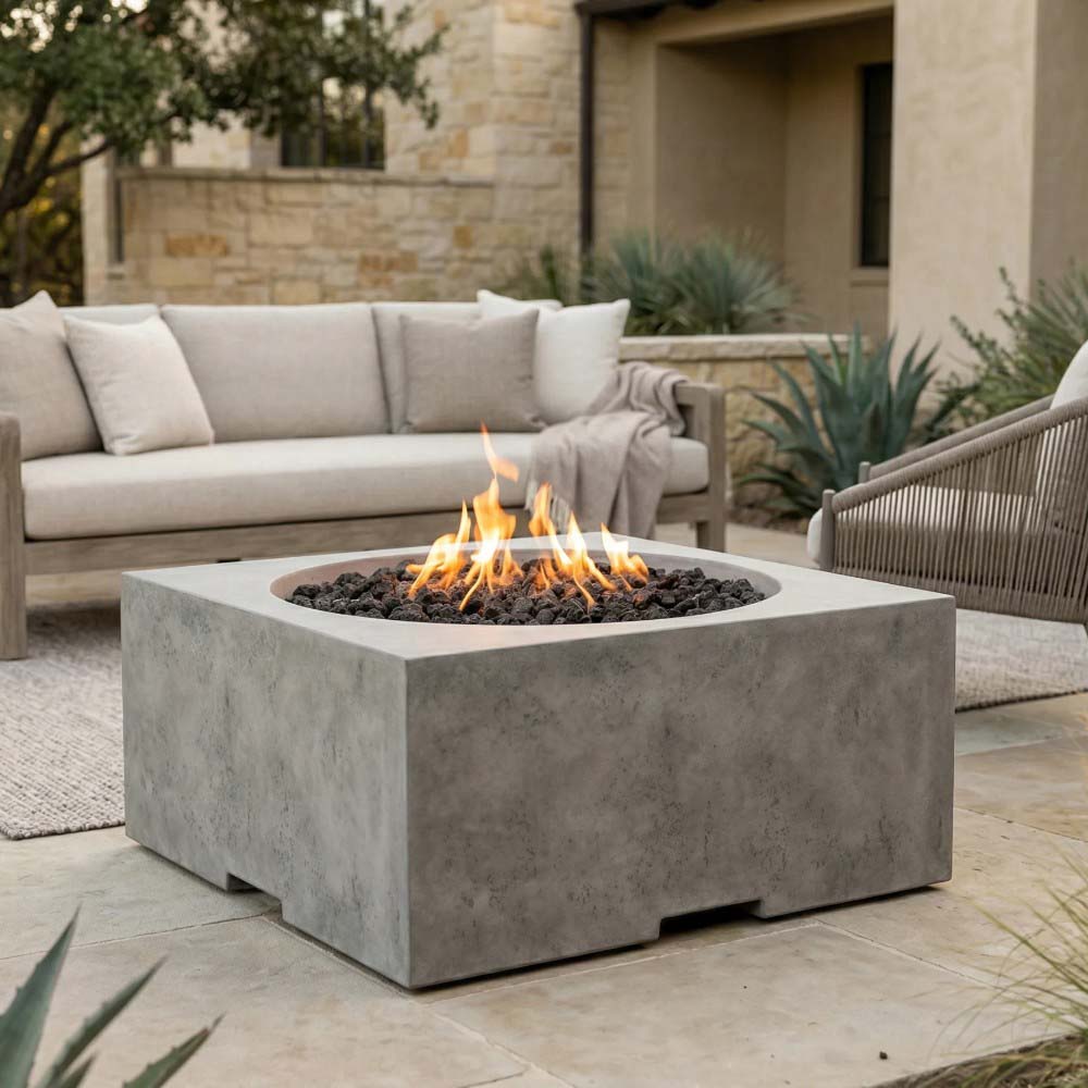 Light gray square concrete gas fire pit with flames over dark lava