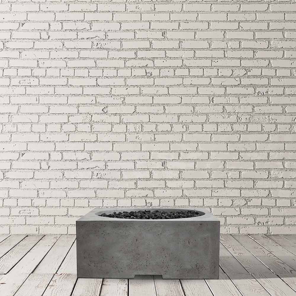 Concrete gas fire pit on deck boards with open flame bowl, dark gray finish.