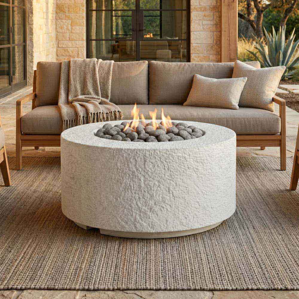 Cylindrical stone-textured concrete gas fire pit with flame and lava rock center
