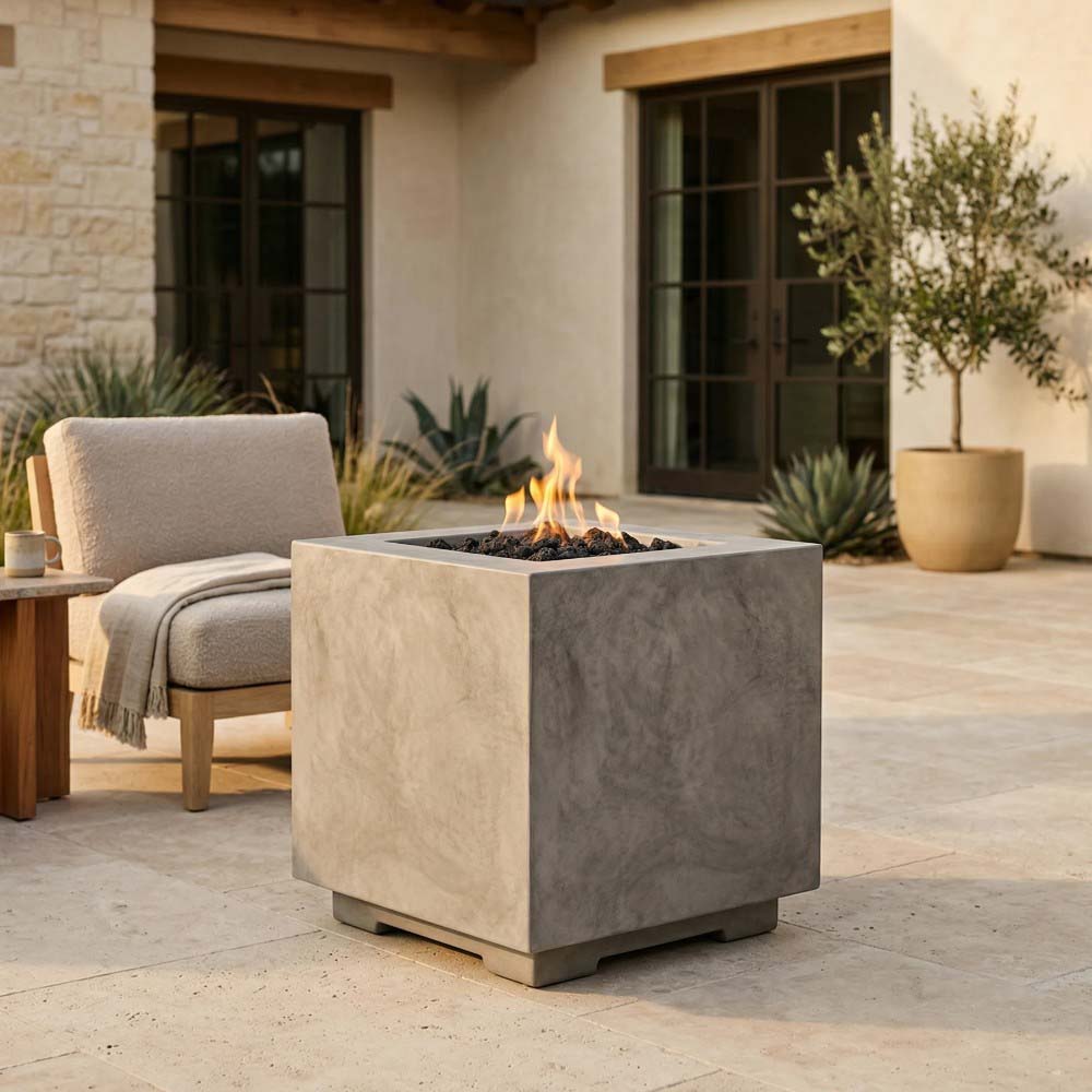 Square concrete gas fire pit with burning flames in a light gray finish