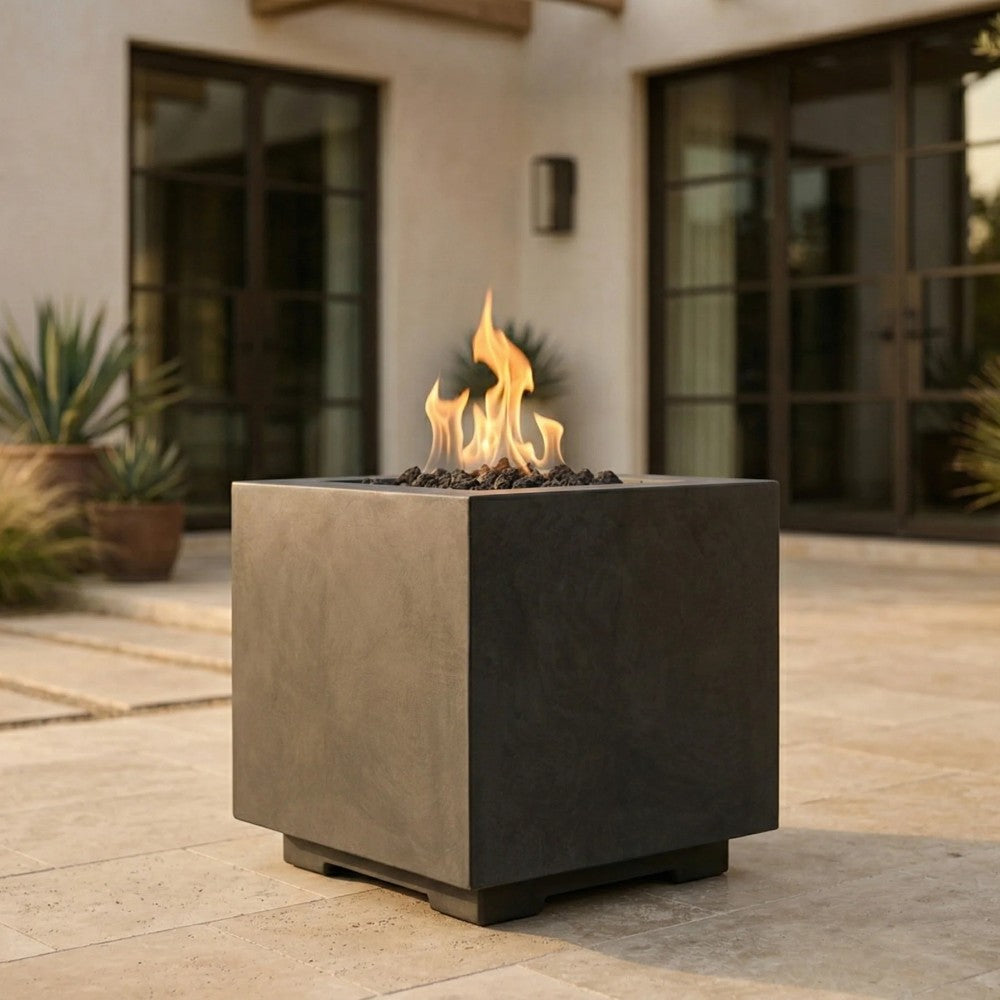 Square concrete gas fire pit burning flames outdoors on a patio
