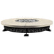 Round concrete natural gas fire pit with dark pebble-pattern base and ignition cap