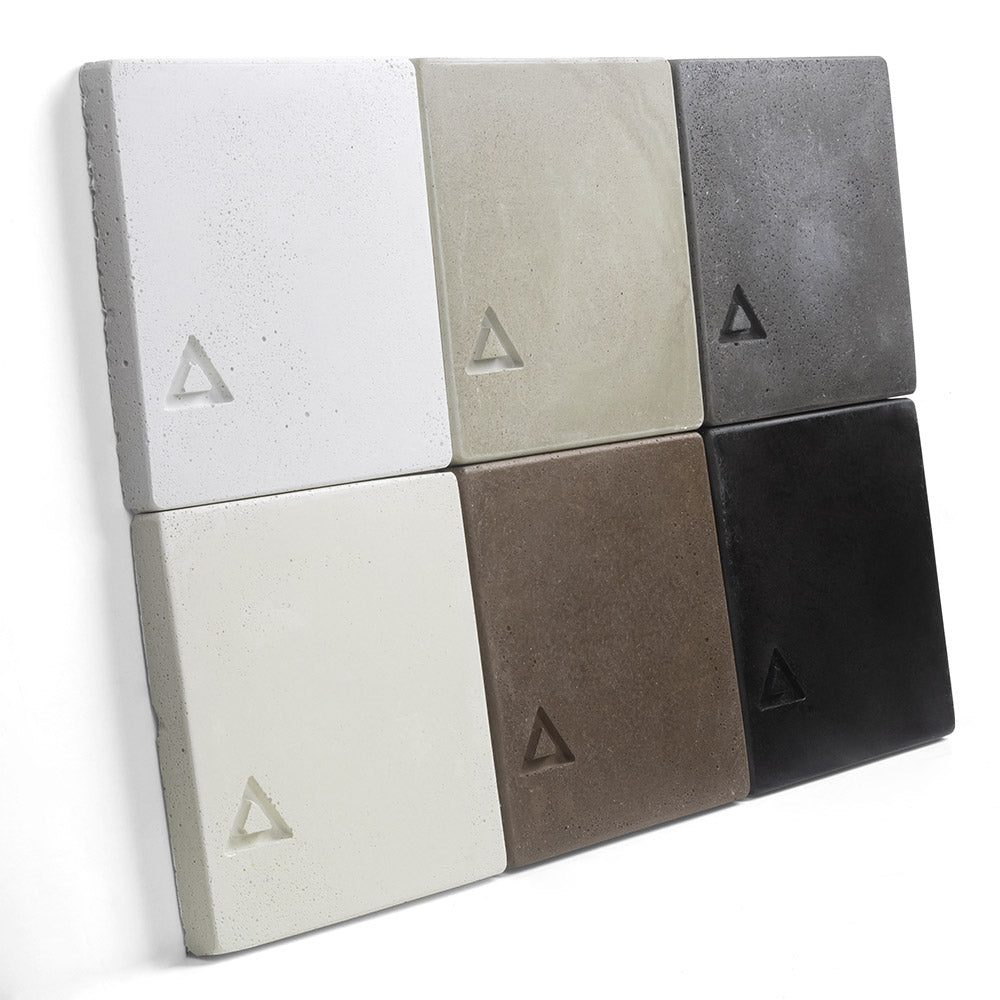 Concrete chip sample display of six squares with triangular logos in white, tan, gray, and black.