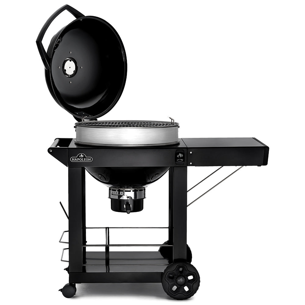 Charcoal kettle grill on cart with lid open, black grill body and silver firebox