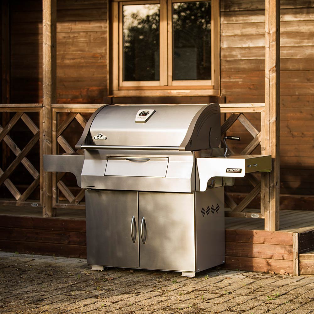 Charcoal grill on cart with domed lid and side shelf