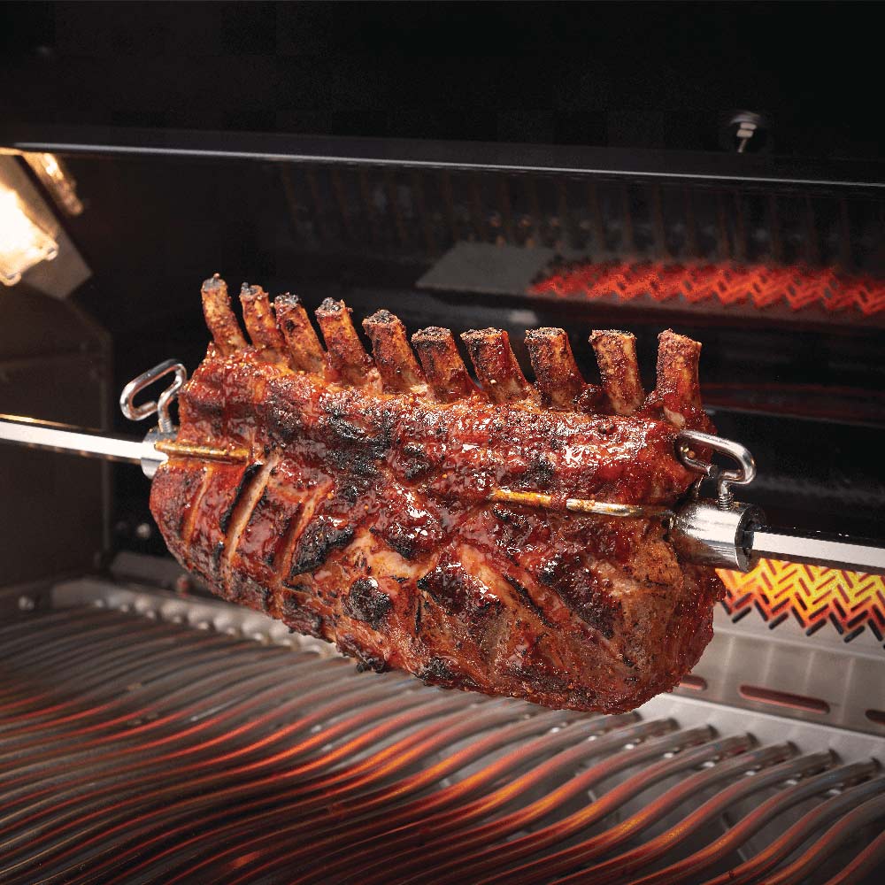 Rotisserie roast on spit with upright forks on the grill grates