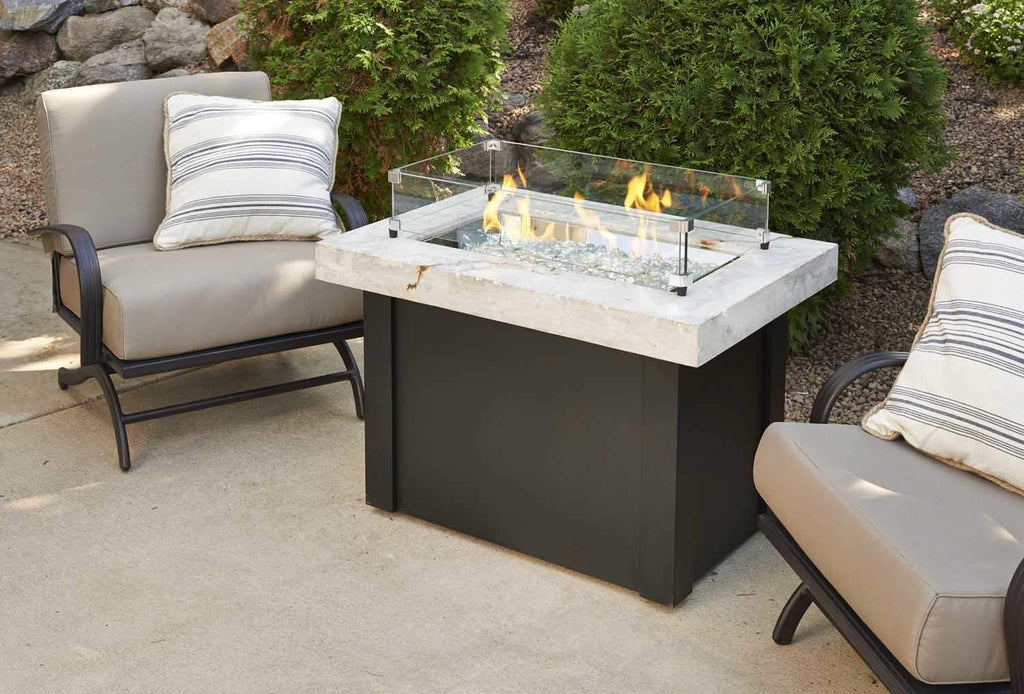 Clear glass wind guard for linear fire burner with metal posts and base