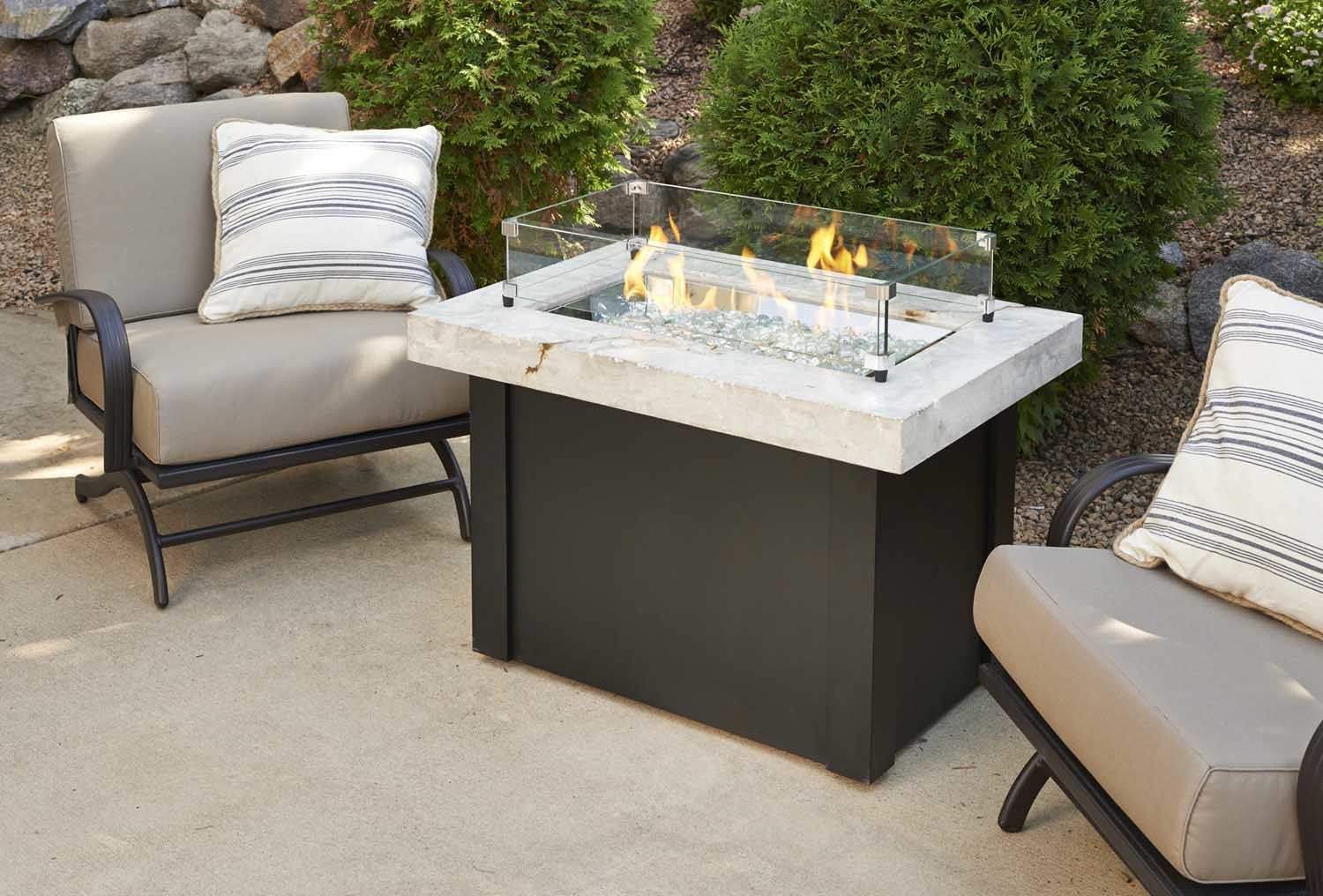 Clear glass wind guard for linear fire burner with metal posts and base