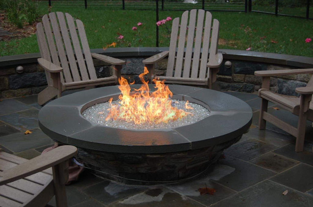 Round metal fire pit burner with visible flames and sparks