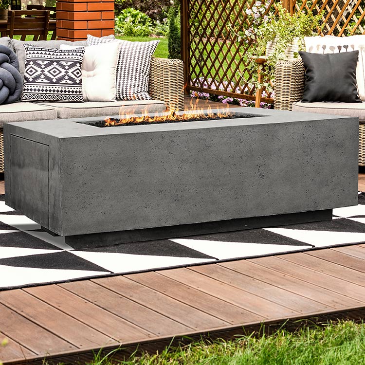 Rectangular concrete gas fire pit on patio with visible flames