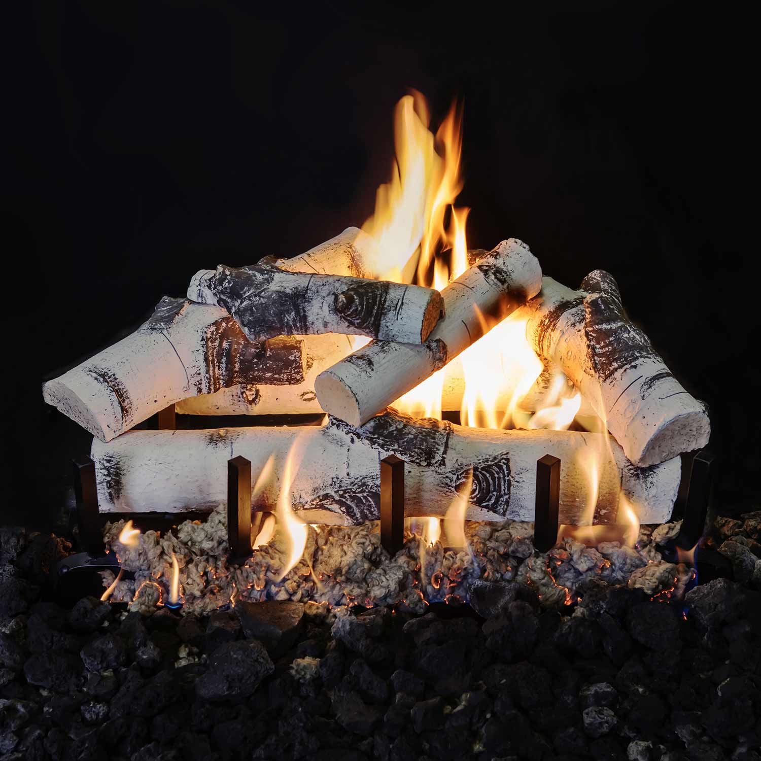Stacked white and black gas fireplace logs with tall flames and glowing embers
