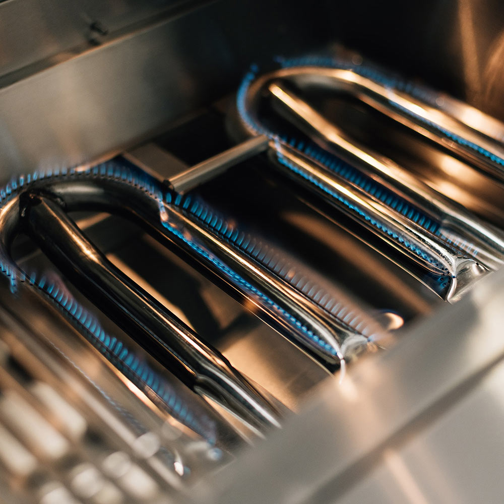 Built-in gas grill burner tubes inside the firebox, stainless steel interior