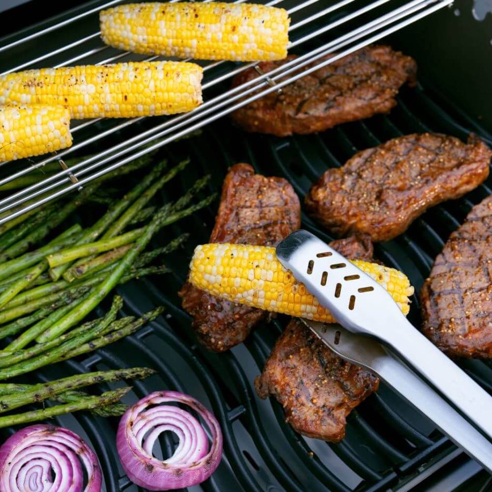 Grill cooking grate with corn, asparagus, and seared meat patties