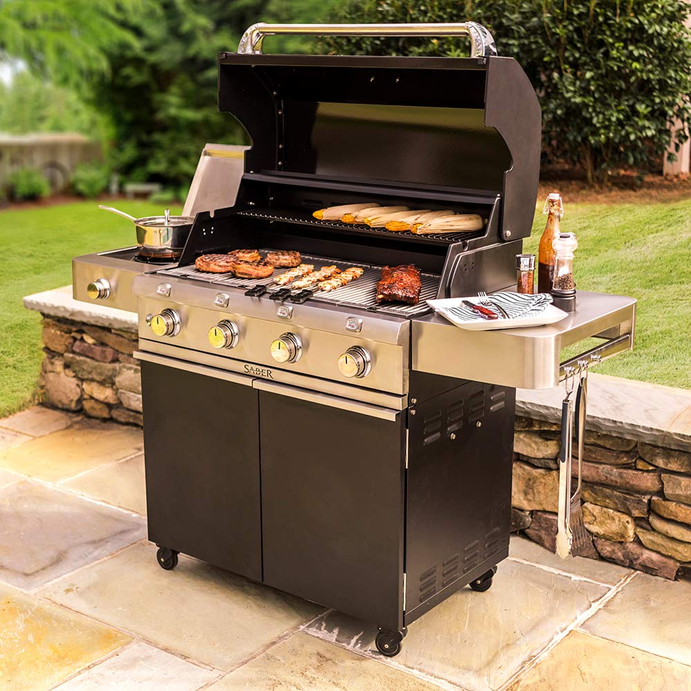 Black infrared grill with open lid, burgers on grates, stainless side shelf