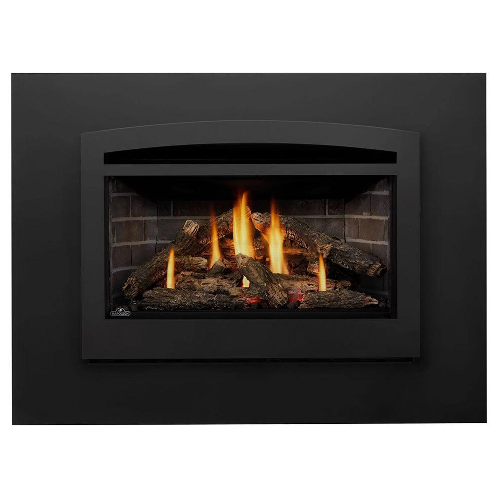 Black direct vent gas fireplace insert with burning logs in dark firebox