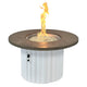 Round gas fire pit table with brown round top and white ribbed base, flame in center