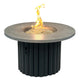 Round gas fire pit table with gray stone top and dark fluted base; flames in center.