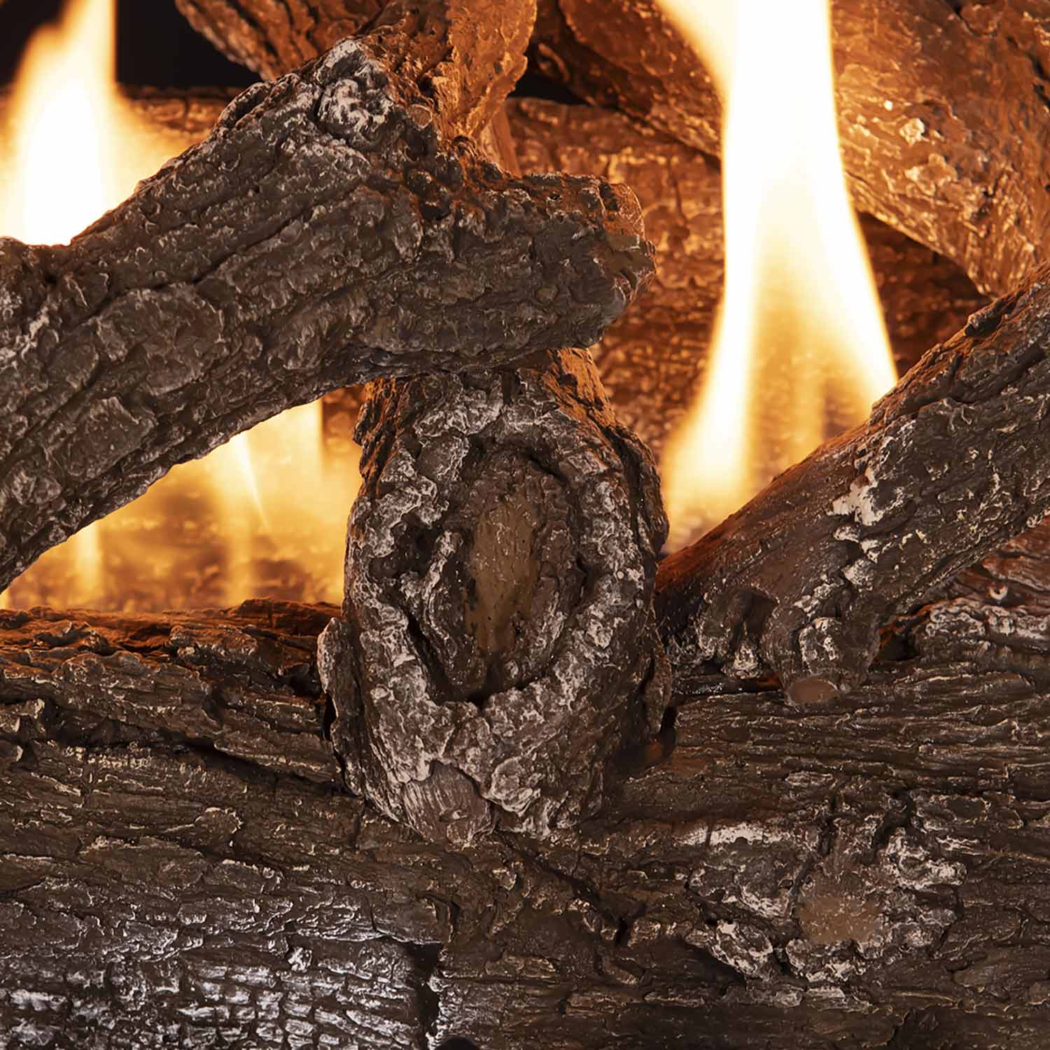 Close-up of vent-free gas logs with orange flames between dark barked wood pieces