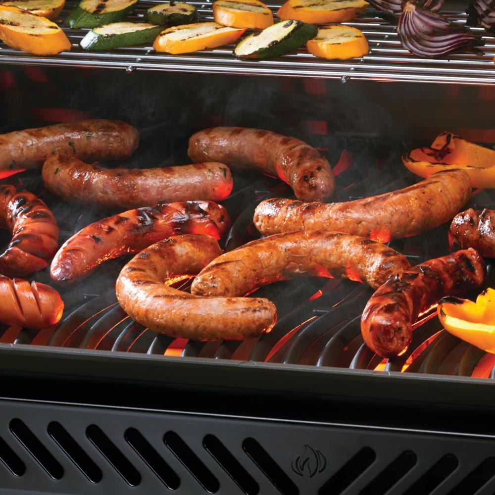 Grill grates with cooked sausages and vegetables inside an open gas grill