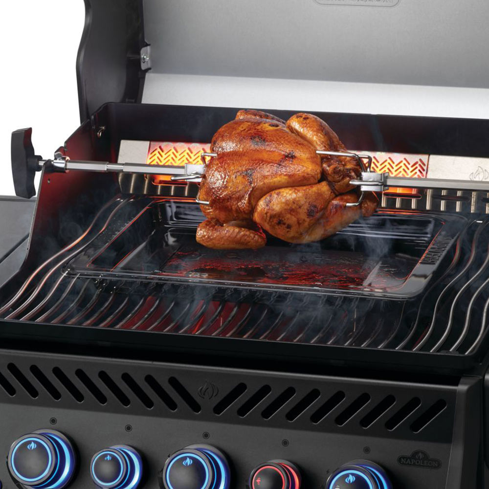 Gas grill interior with whole chicken roasting on grill grates
