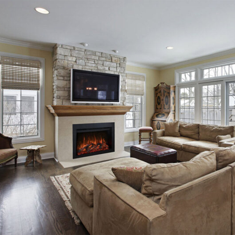 Tall stone fireplace surround with black framed electric insert showing orange flames