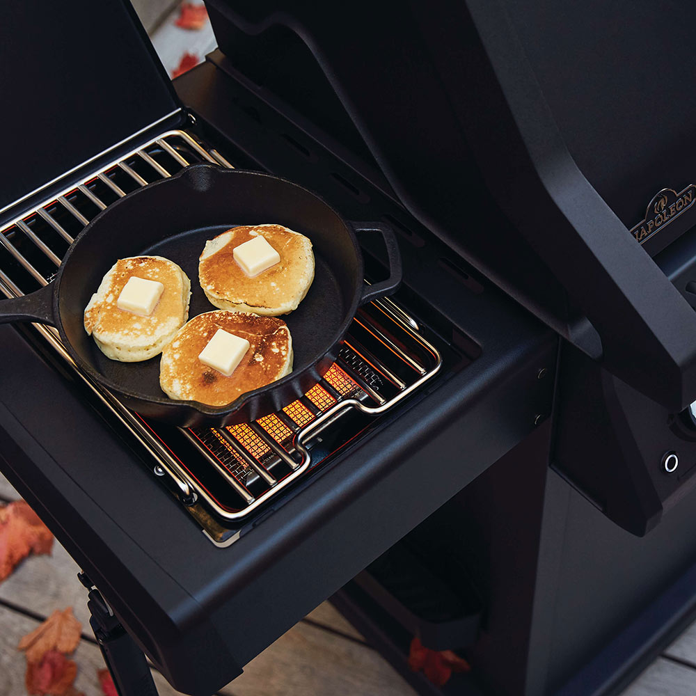 Black side burner cooking grate with skillet holding bread slices