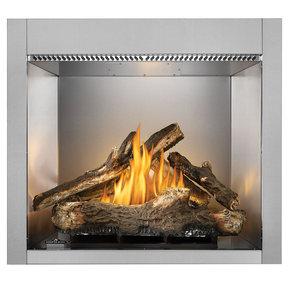 Outdoor gas fireplace with burning wood logs and yellow flames inside gray metal firebox