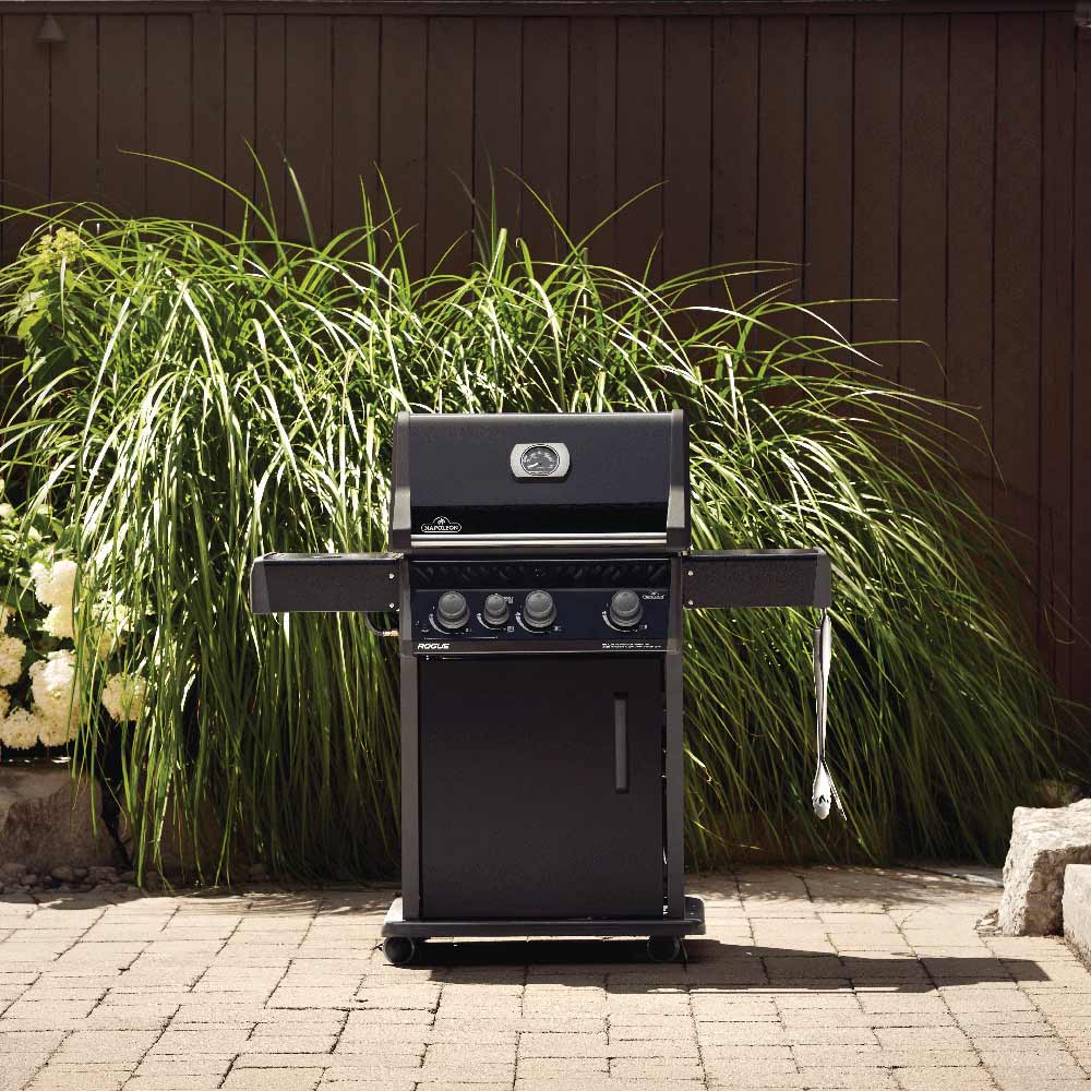 Black gas grill on cart with closed lid outdoors