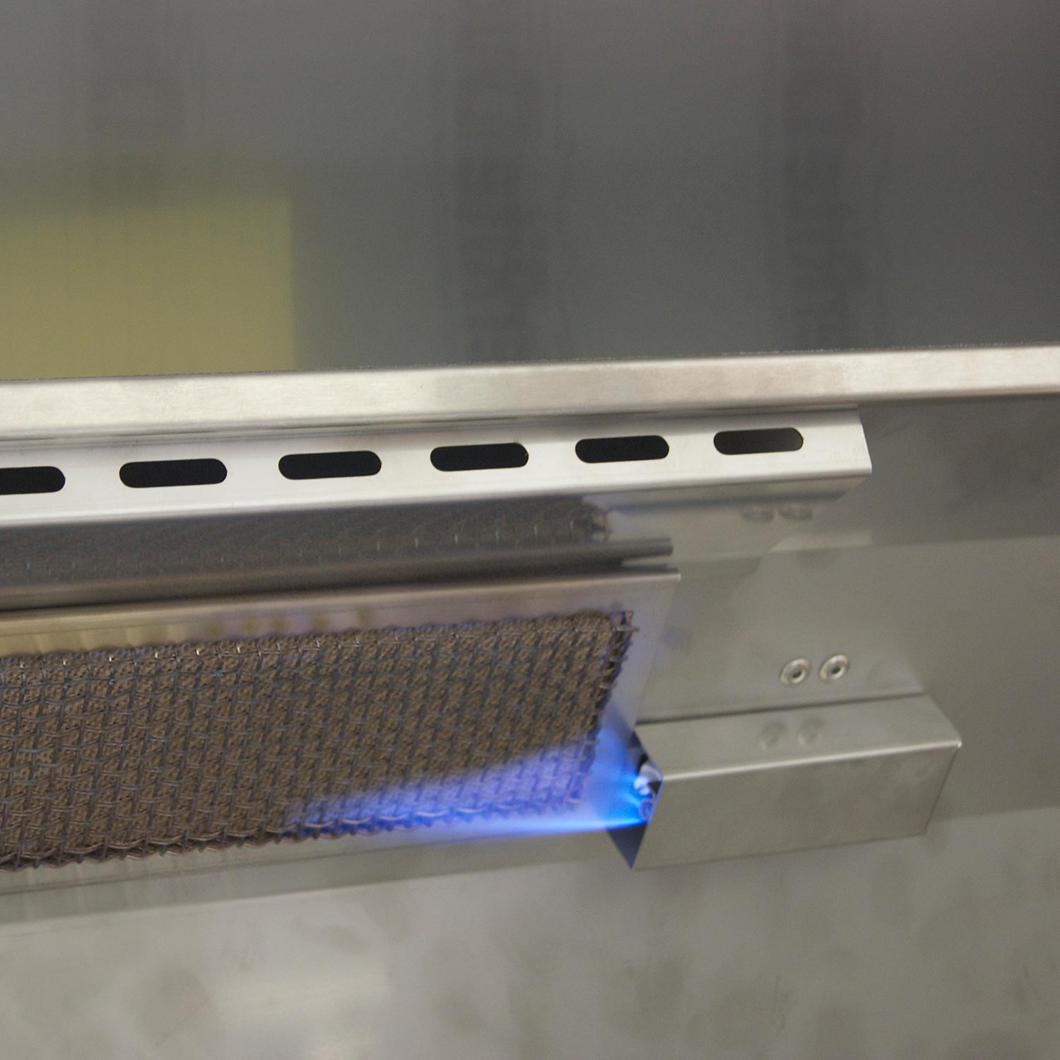 Infrared burner area with blue flame igniting under the grill grate
