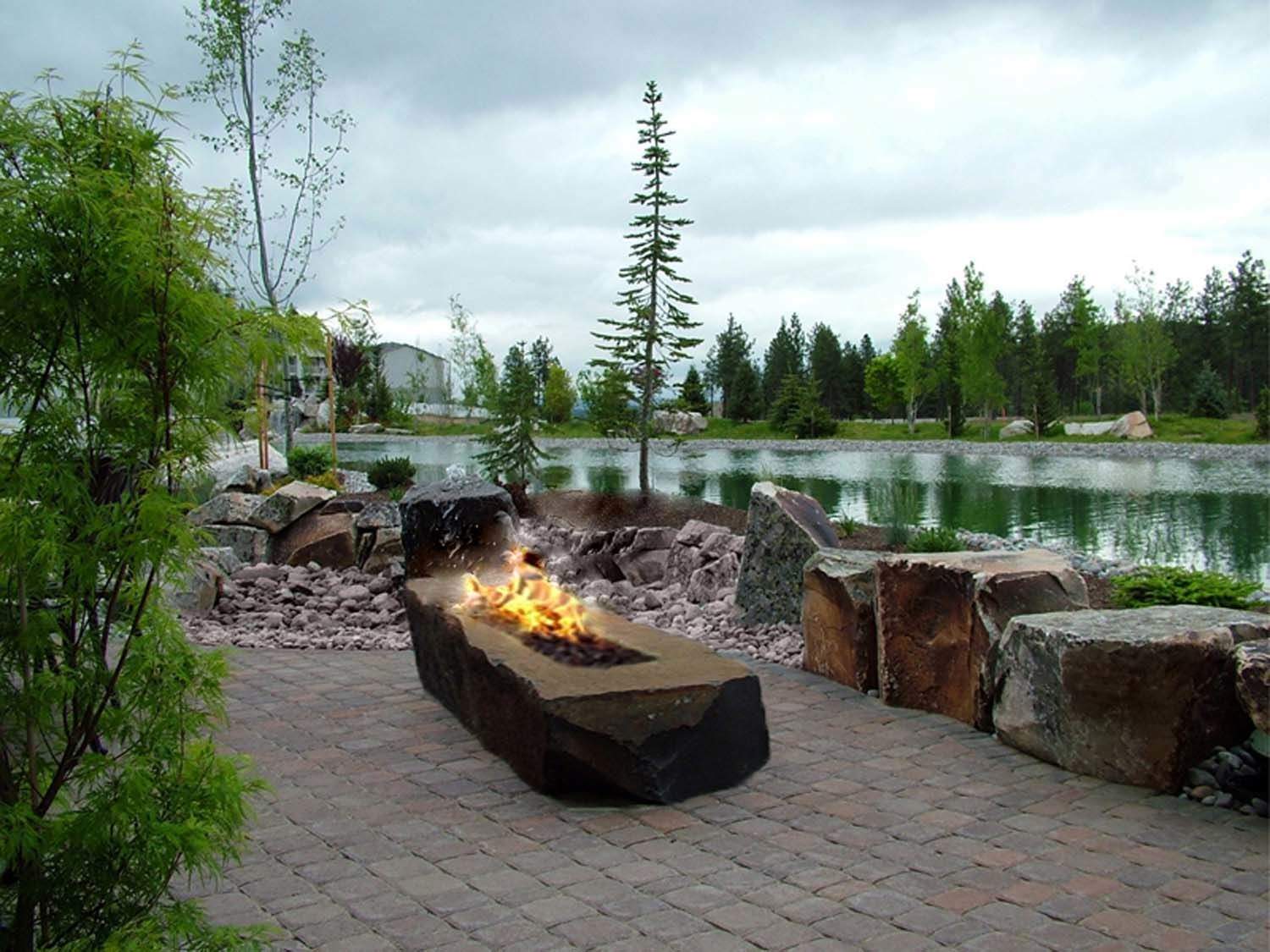 Outdoor rectangular gas fire pit with stone surround and visible flames