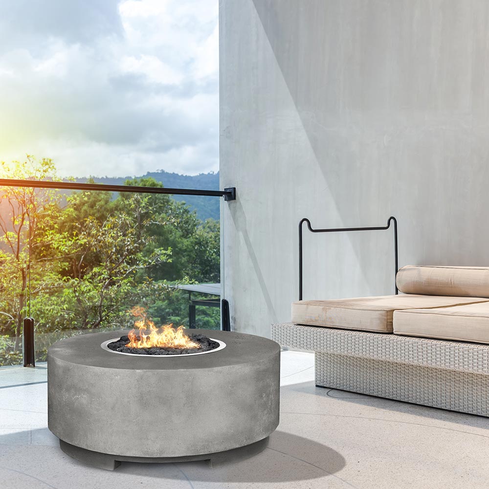 Round concrete gas fire pit with flames, gray finish on outdoor deck