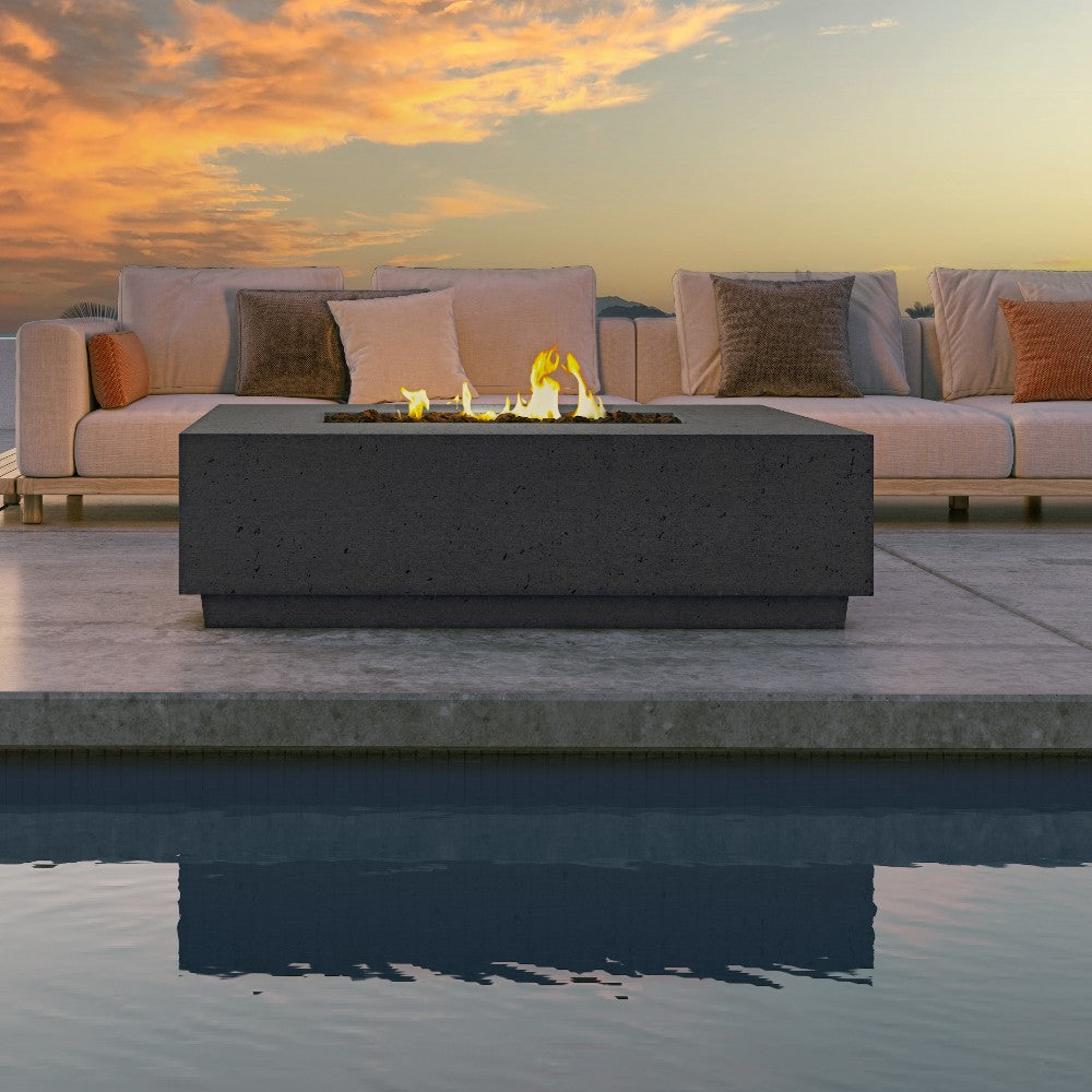 Gas fire table with glowing flames in an open rectangular burner, dark stone body.